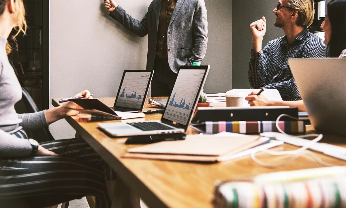 Equipe reunida em um escritório para uma conversa de trabalho.